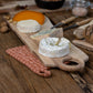 Acacia wood cheese board with four kinds of cheese on wooden table